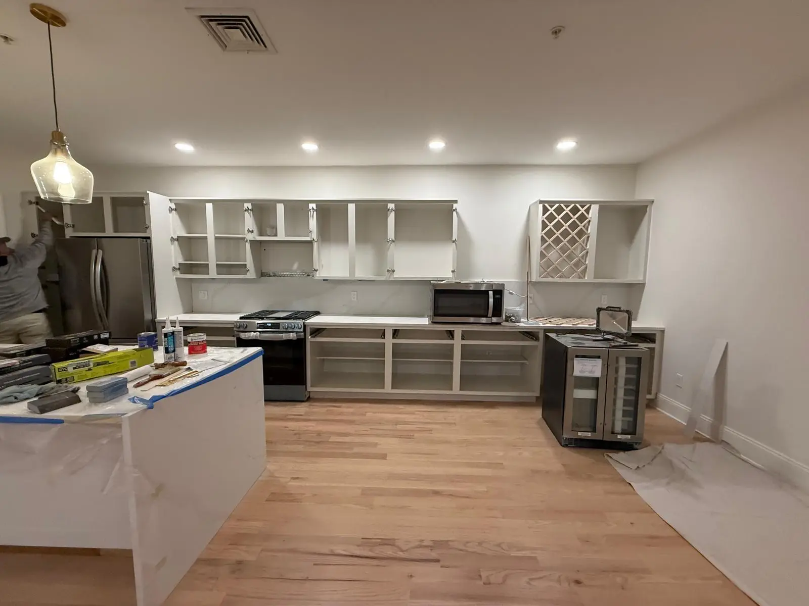 Cabinet boxes painted with doors and drawer fronts removed, floor protected with paper