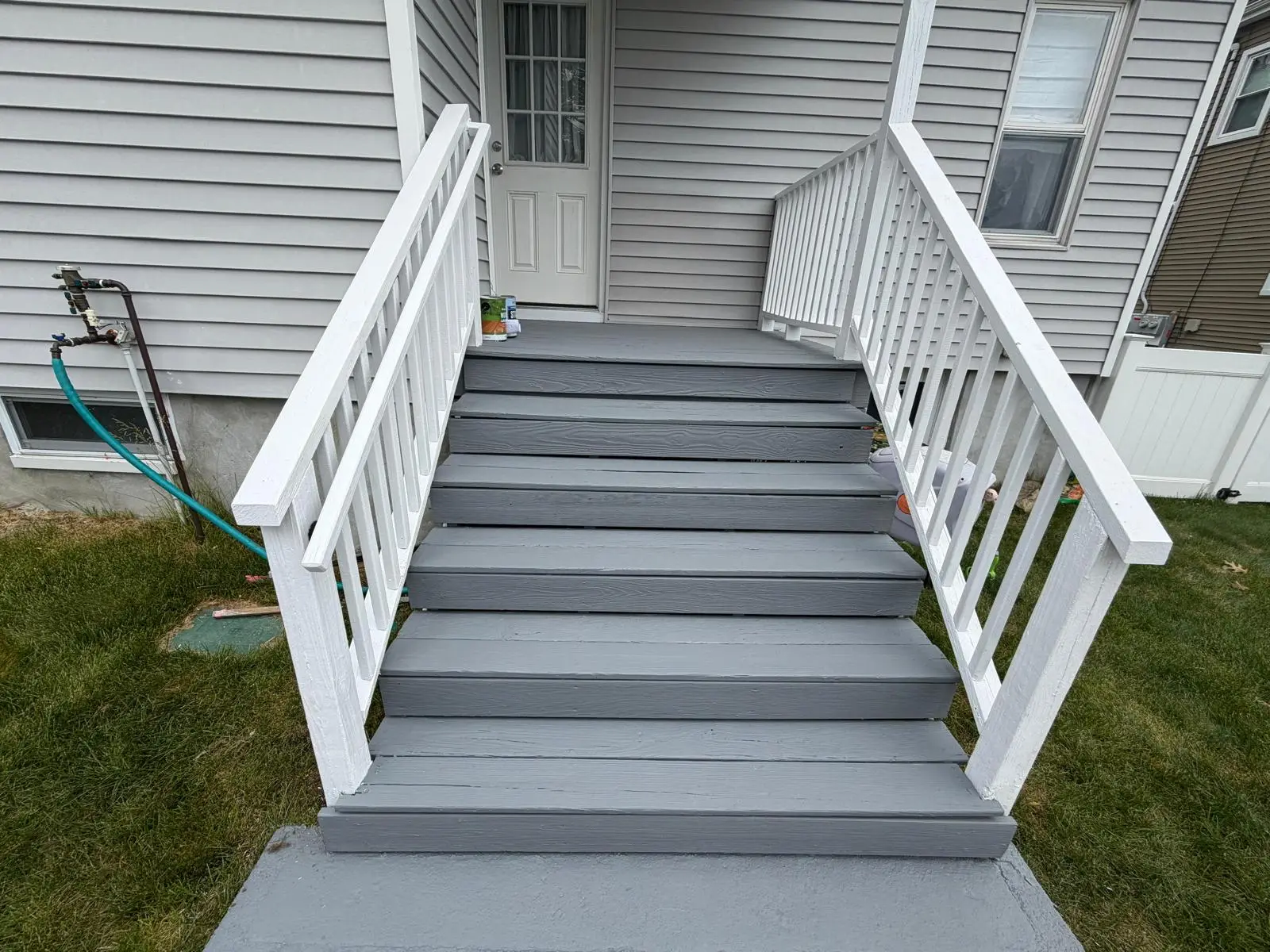 Back stairs painted gray with white railings and balusters in Norwood, MA