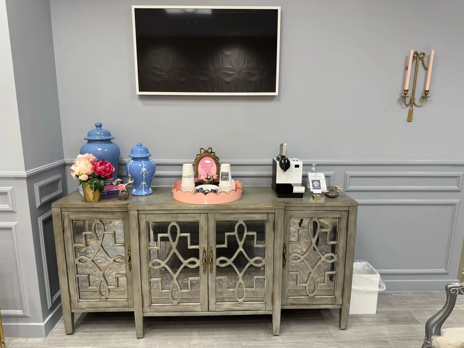 Close view of gray paneled wall above a mirrored sideboard in a dental office