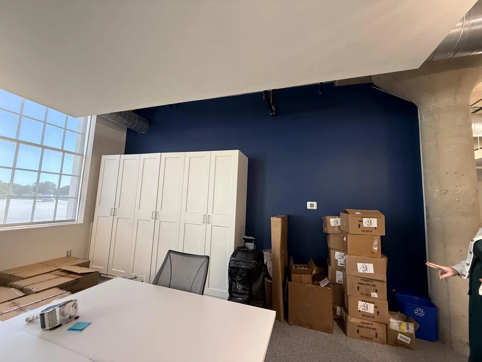 Navy blue accent wall next to a concrete column in an open loft office
