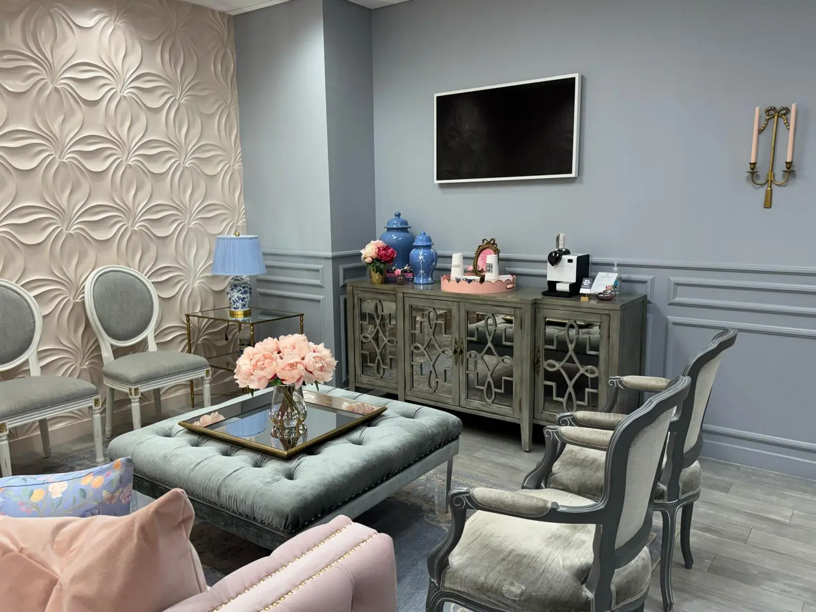 Waiting room with gray walls, applied panel molding and a mirrored sideboard