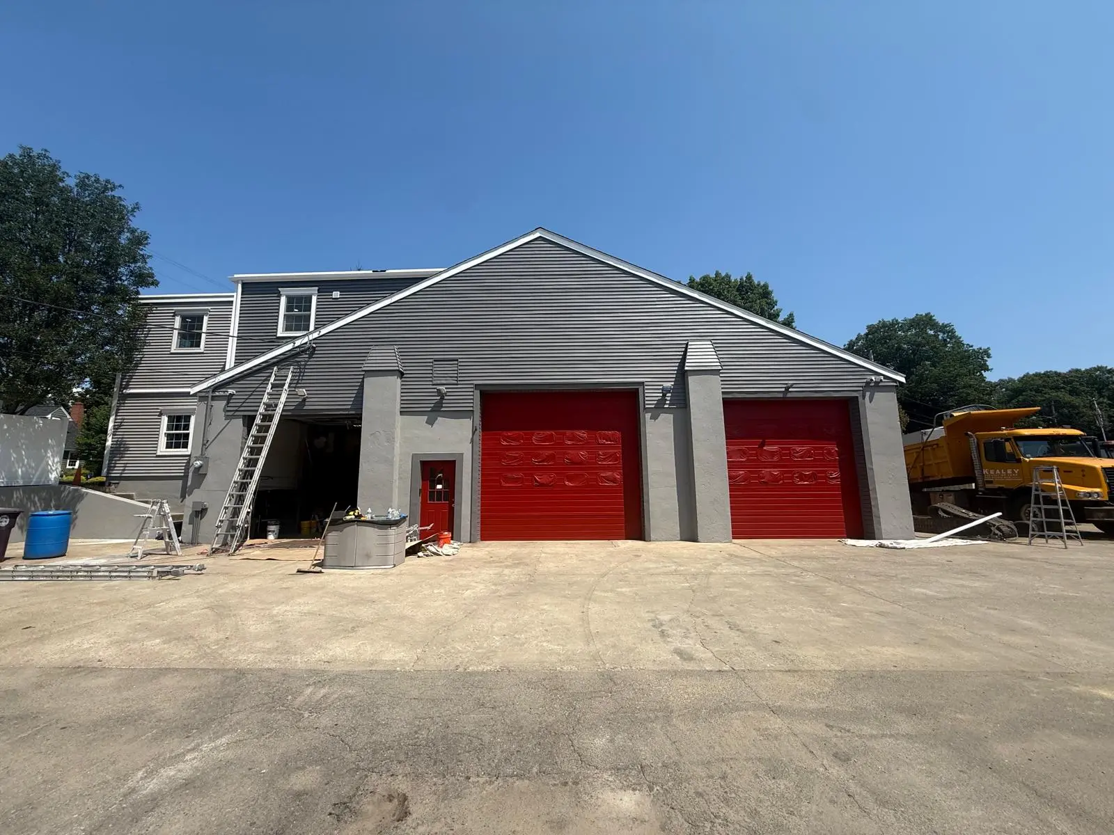Front of the Weymouth garage building after painting, red doors and gray trim
