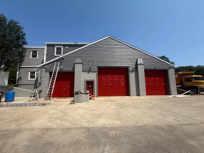 Weymouth garage after painting: red overhead doors and gray masonry pilasters